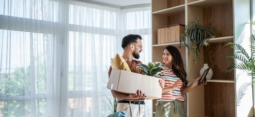 Young,Smiling,Couple,Is,Unpacking,And,Arranging,Belongings,In,Their